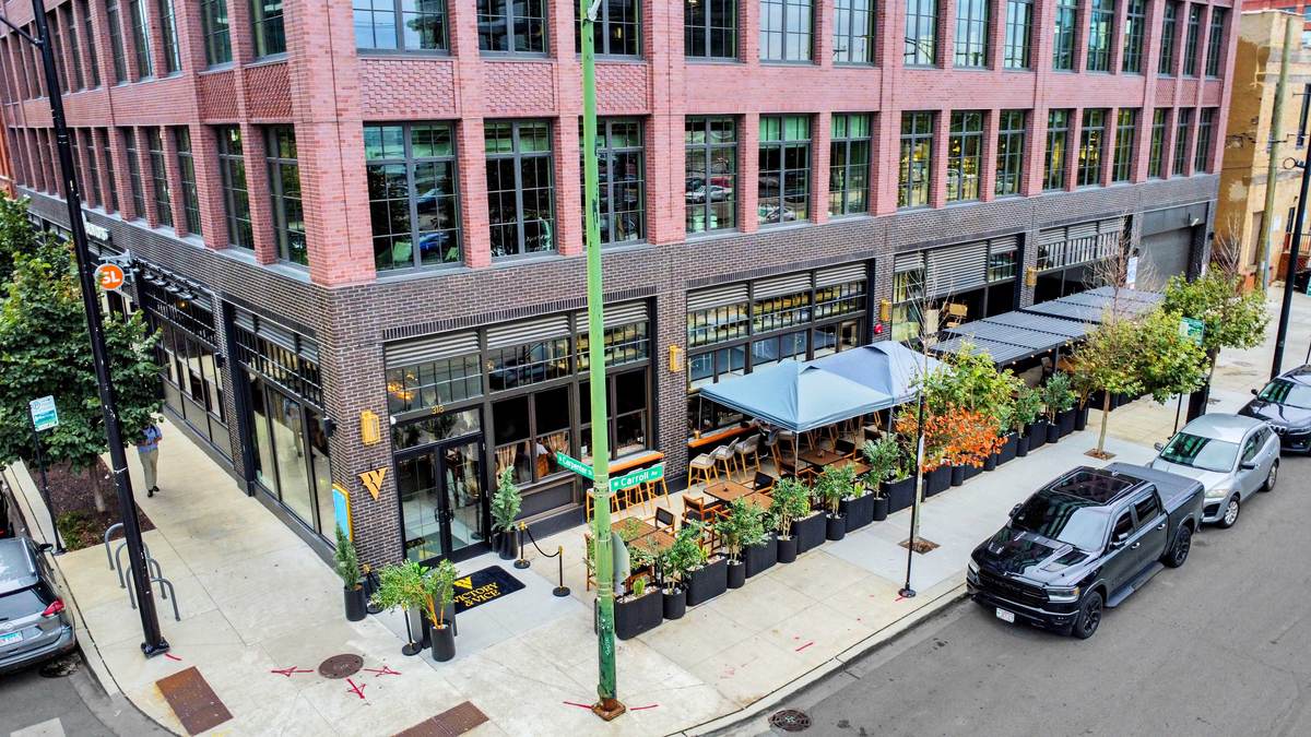 The building from above, the patio and its umbrellas wrapping the street corner.