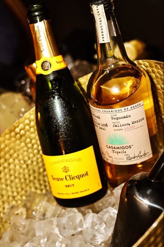 Champagne and tequila on ice in a gold bucket.