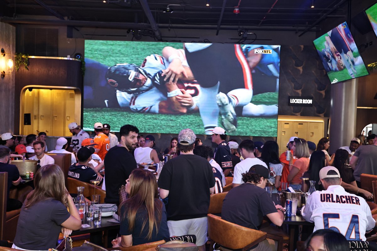 A packed dining room watching the game together on the big screen.
