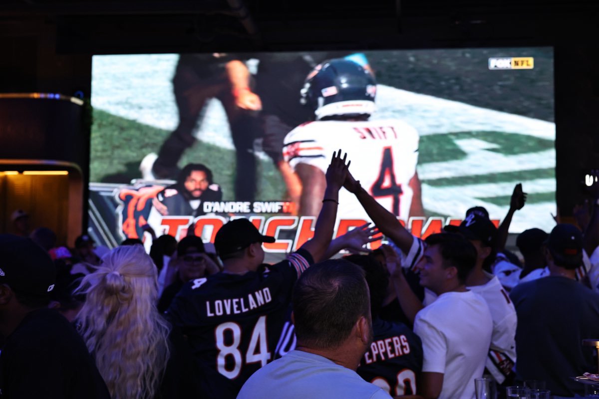 The room on its feet as a touchdown lands on the seventeen-foot screen.