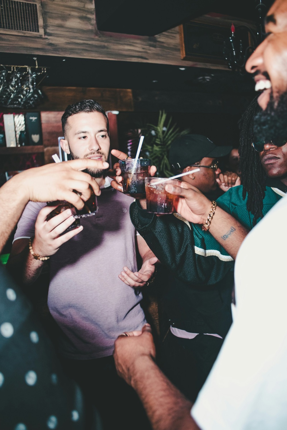 A group of guys raising their drinks together on a night out.