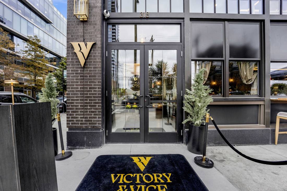 The front door on Carpenter Street, the gold V on the brick and the Victory & Vice mat at the entrance.