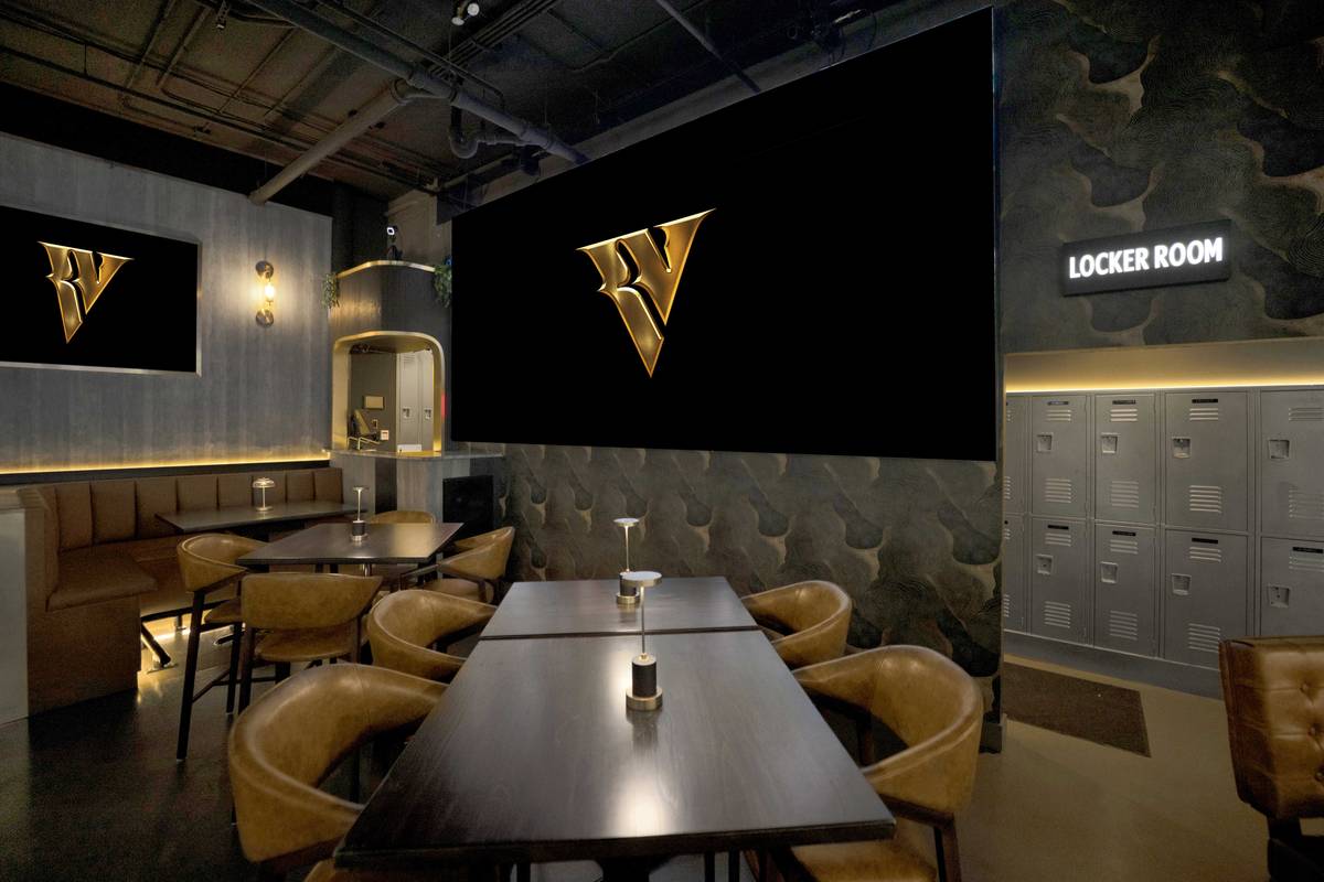 The Locker Room: leather chairs, lockers along the wall and the lit V on the screen.
