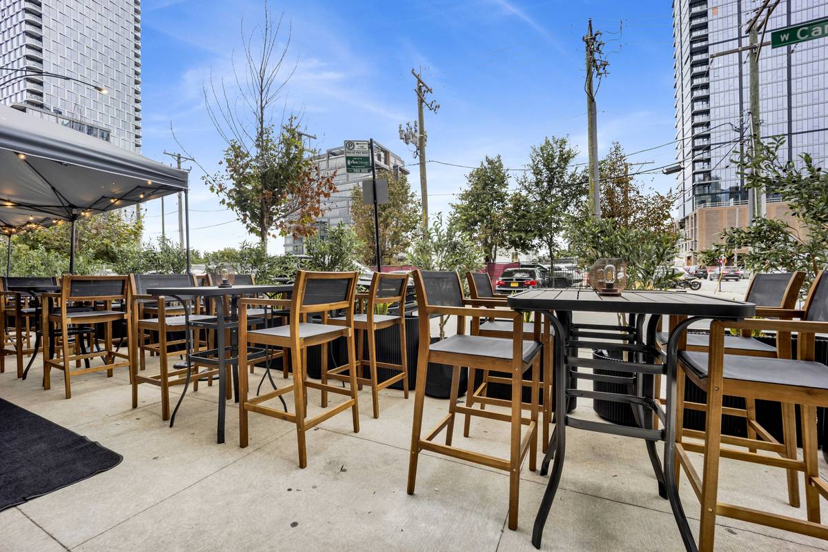 The patio under its canopy, high-top seats lined along the sidewalk.